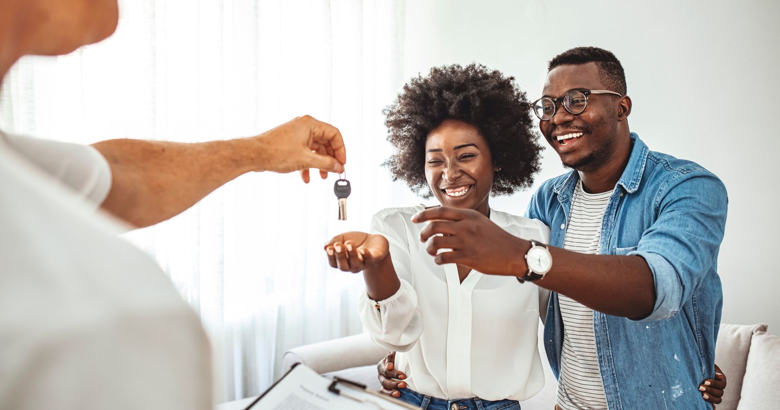 Real estate agent handing house keys to a smiling couple